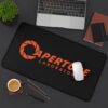 Aperture Laboratories orange logo black desk mat - angled desk view with a mouse Black Portal desk mat with a large orange Aperture Laboratories logo, angled desk view with a mouse